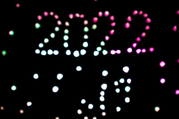 2022 lettering made with lights on dark background. bokeh view.