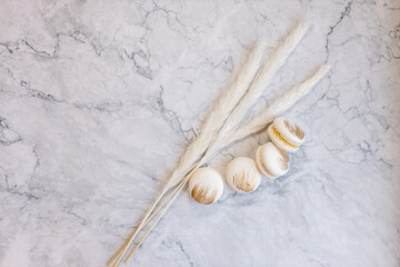 White macarons lie on a marble table. Delicious light cookies on a light background. Bakery