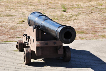 Old cast iron cannon on wooden wheels. A cannon on a wooden gun carriage. Background.