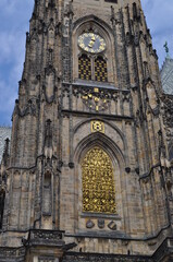 Fototapeta na wymiar Catholic cathedral. Clock on the building of the cathedral and an openwork window made of yellow metal.