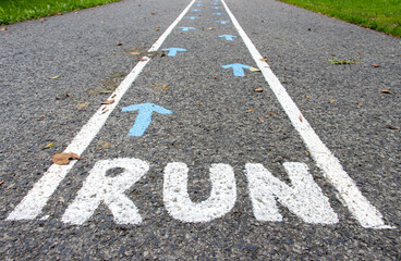 Obraz premium A direction arrows with RUN instruction on asphalt road