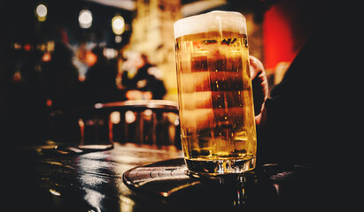 man hold a glass of beer in his hand at the bar or pub