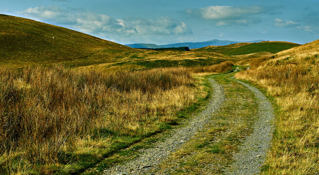 Scene of an old mining road from Glaspwll near Machynlleth that follows the route of a bridleway making it ideal for mountain bikers. Taken from Bwlch Hyddgen with Cadair Idris in the background.