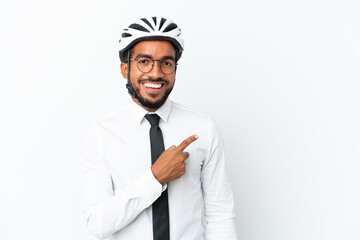 Young business latin man holding a bike helmet isolated on white background pointing to the side to present a product