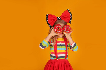 beautiful girl with a red bow on her head in a red skirt, a colored blouse holds pink donuts