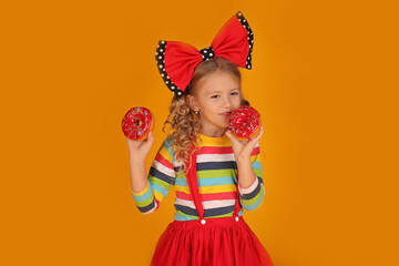 beautiful girl with a red bow on her head in a red skirt, a colored blouse holds pink donuts
