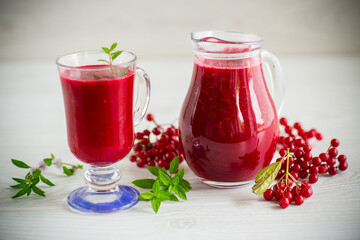 freshly squeezed thick natural juice with pulp from ripe red viburnum in a decanter