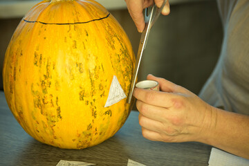 Making Jack O'Lantern at home. The pumpkin is ready for slicing. The man and the woman are happy...
