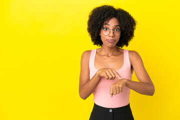 Fototapeta na wymiar Young African American woman isolated on yellow background making the gesture of being late