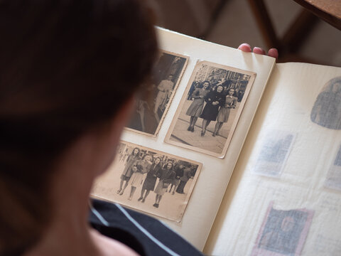 Lady Looking at old Black and White Vintage Photos Scrolling through the Pages of a Photo Album
