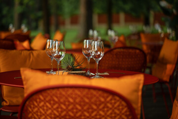Served dinner table with four empty wine glasses in restaurant terrace in pine wood