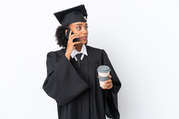 Young university graduate African American woman isolated on white background holding coffee to take away and a mobile