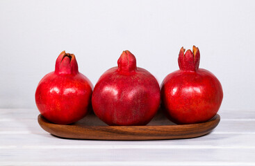 Wooden Plate with ripe Pomegranates on white background, Red Fresh Fruits, Raising Hemoglobin