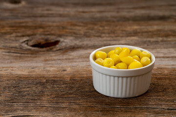 yellow hot pepper pickle on wooden background. Copy space