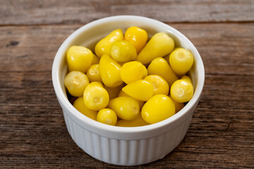 yellow hot pepper pickle on wooden background