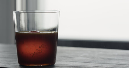 coffee pour over ice ball in tumbler glass on black wood table