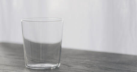 empty tumbler glass on black oak table