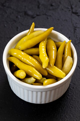 Green chilli pepper pickled on dark background