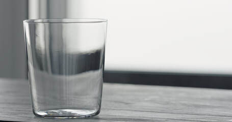 empty tumbler glass on black oak table