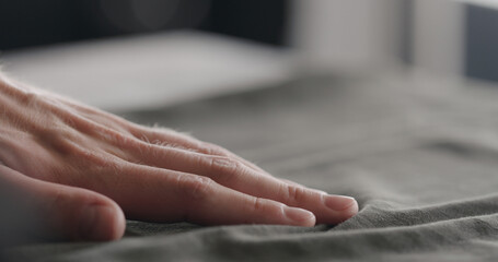 man touching green cotton clothes closeup