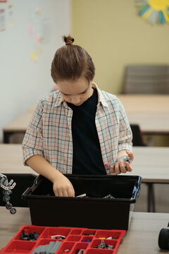 Boy Works on a Fully Functional Programable Robot for His School Robotics Club Project.