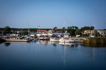 A yacht marina in Dziwnow, Poland. 
Sailings boats and harbor buildings, sunny day, blue sky.
Background with copyspace.