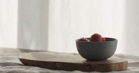fresh strawberries from blue bowl on linen cloth