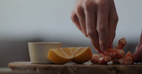 man serving crab with dip sauce and sliced sweed lemon