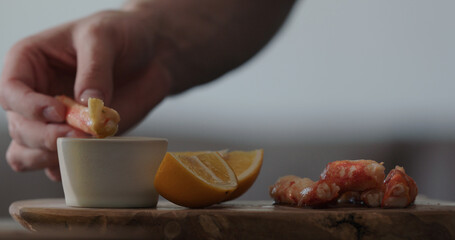 man eating crab with dip sauce