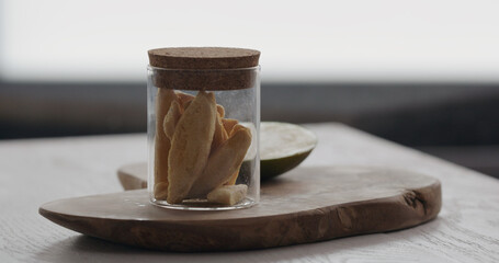 freeze dried mango in glass jar on olive wood board