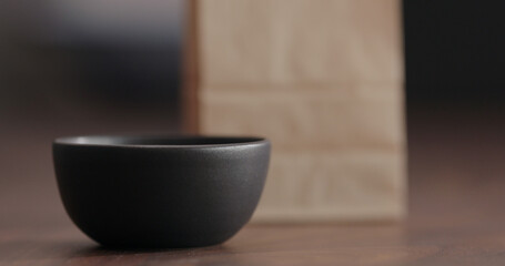 Black empty ceramic bowl on walnut table