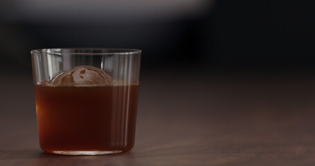 coffee pour over ice ball in tumbler glass on black walnut table