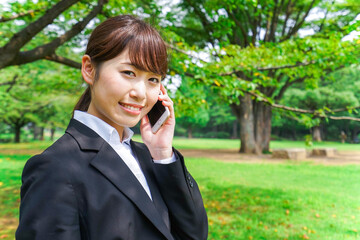 電話をするスーツ姿の若い女性