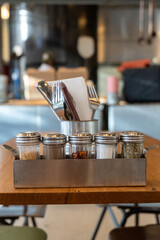 Salt and black pepper ingredients shakers in a autumn cafe, a wooden table in a restaurant. Spices, ingredients in cooking