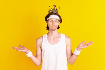 Portrait of attractive sportive cool guy wearing golden crown isolated over bright yellow color background