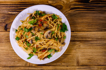 Pasta with mushrooms and tomato sauce in a plate. Top view