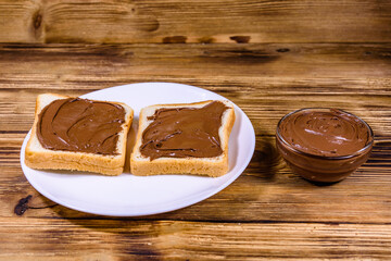 Two sandwiches with chocolate spread on a white plate