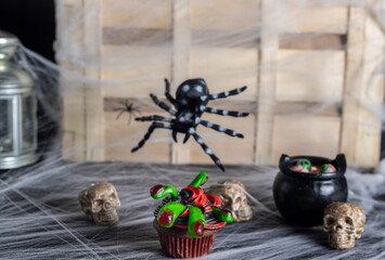 A halloween cupcake, chocolate, red and black battercream and gumdrop fingers. Horizontal shot and selective focus