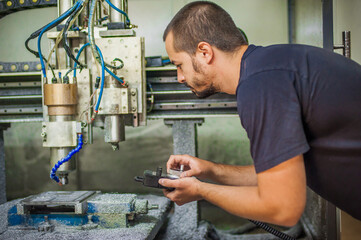 Engineer worker technician operating with CNC milling metal engraving machine