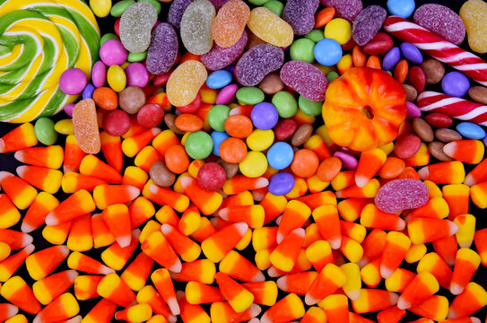 Mixed halloween candy background close-up top view stock images. Halloween sweet candy corn, lollipop, pumpkin stock photo. Different types of candies images