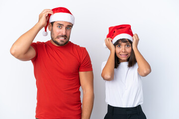 Young couple with christmas hat isolated on white background takes hands on head because has migraine