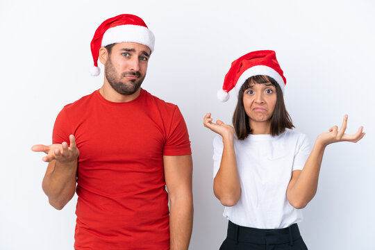 Young Couple With Christmas Hat Isolated On White Background Unhappy And Frustrated With Something Because Not Understand Something