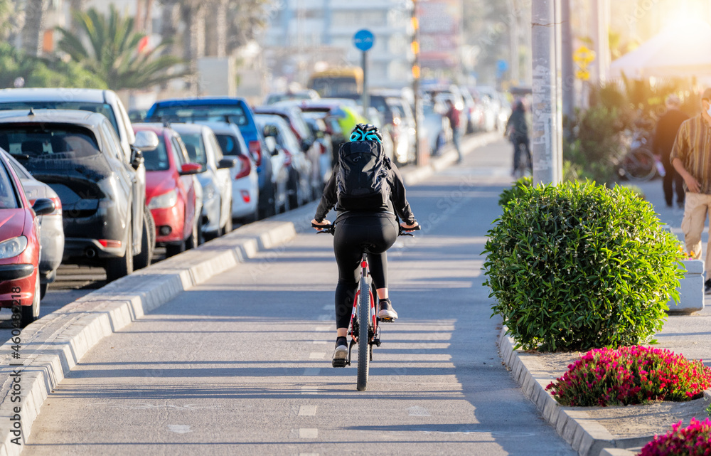 Wall mural woman riding a bicycle on a bikeway at sunset in La Serena, Chile