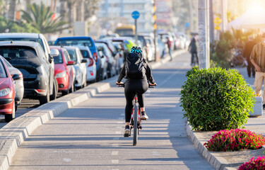 woman riding a bicycle on a bikeway at sunset in La Serena, Chile