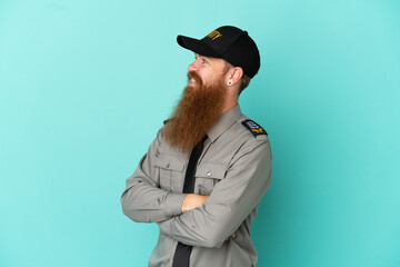 Redhead security man isolated on white background with arms crossed and happy