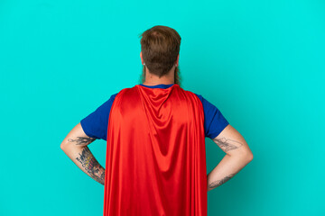 Redhead man in superhero costume in back position