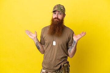 Redhead Military man with dog tag isolated on yellow background having doubts while raising hands