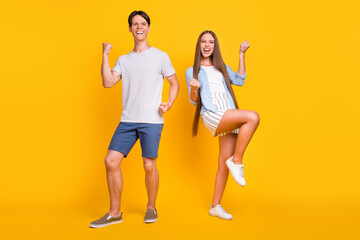 Full length body size view of attractive cheerful couple rejoicing having fun isolated over bright yellow color background