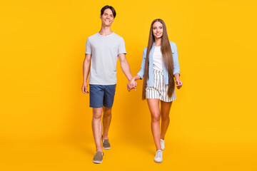 Fototapeta premium Full length body size view of attractive cheerful couple family spending time going isolated over bright yellow color background