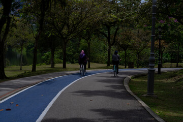 City park famous place for cycling outdoor. People riding bicycle in the lane in the park during weekend. 